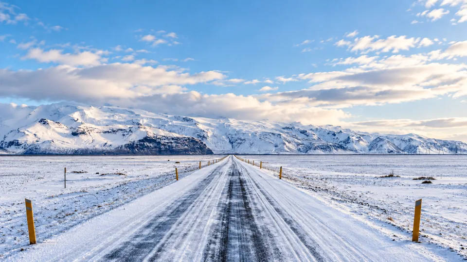 Paved Iceland road in snowy open terrain in daylight