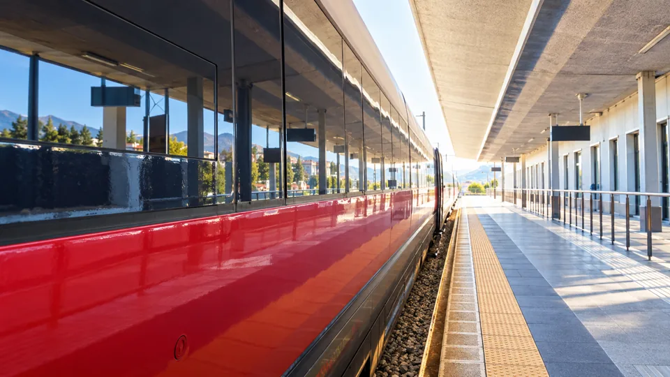Red high speed train beside an Italian platform