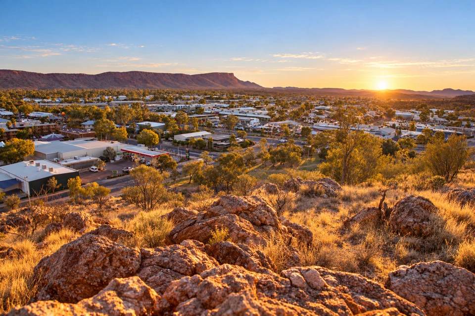 Alice Springs' low-rise town and eucalyptus trees below the MacDonnell ridge, seen from Anzac Hill.