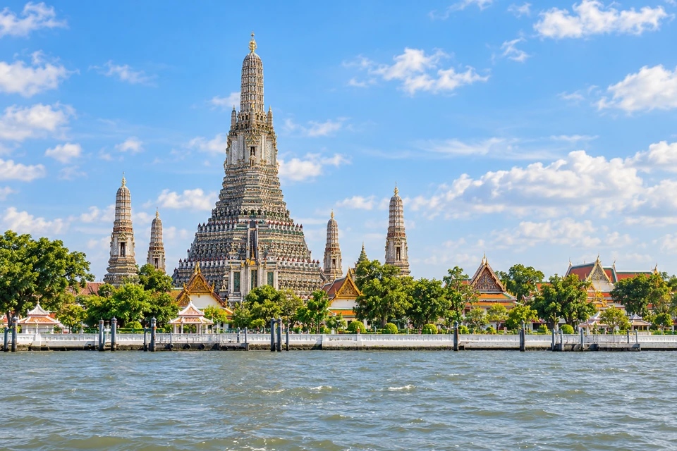 Wat Arun's mosaic-covered prang and satellite towers across the Chao Phraya River.