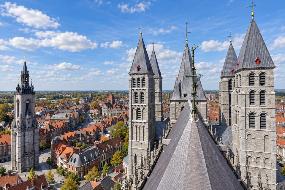 Grey stone towers and slate roofs of Tournai Cathedral, with the separate city belfry at left.
