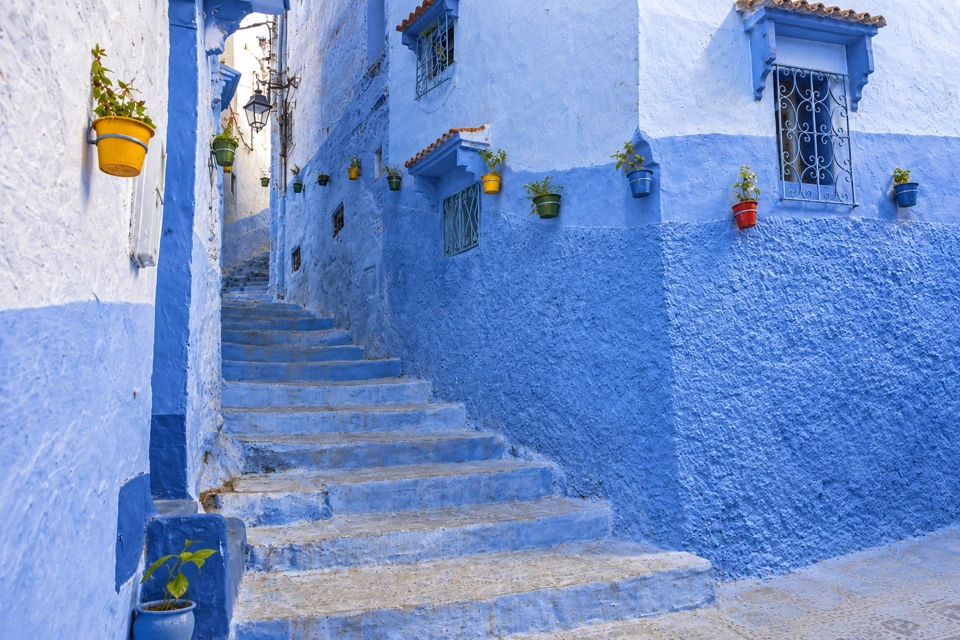 Worn bluewashed steps between the textured walls of Chefchaouen's medina.