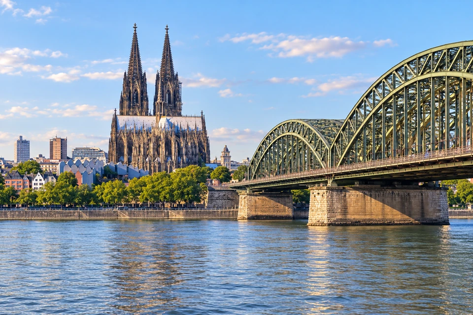 Cologne Cathedral's twin spires beside the Hohenzollern Bridge across the Rhine.