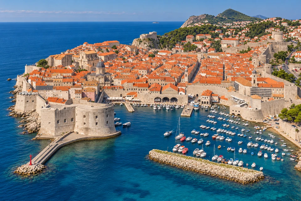 Dubrovnik's old harbor sits between St John's Fortress, the Porporela pier and the Kaše breakwater below the walled red-roofed old town.
