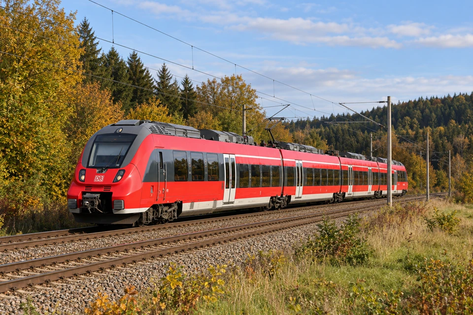 A red DB Regio Talent 2 regional train on an electrified rural railway in Germany.