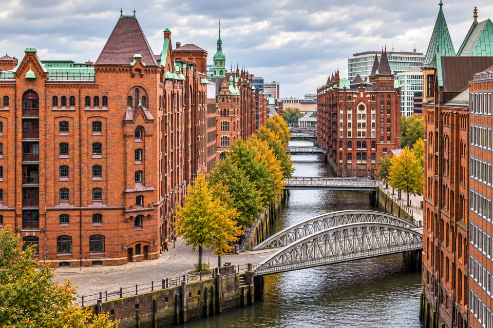Red-brick Speicherstadt warehouses and a steel canal bridge in Hamburg.