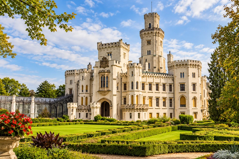 Hluboka Chateau's pale crenellated towers above its clipped formal garden.