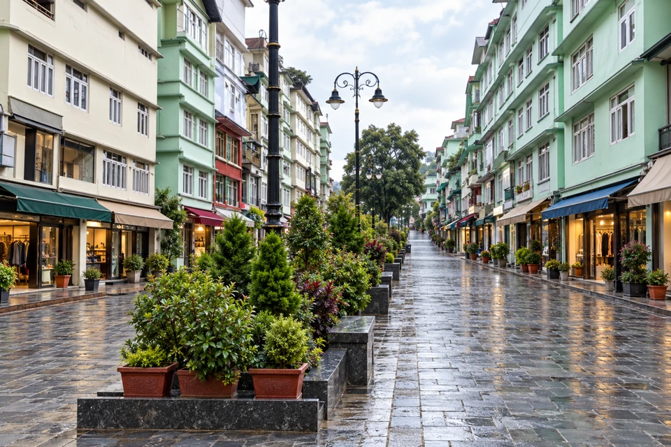 MG Marg in Gangtok with pale green facades, central planters, paired lanterns and damp stone paving