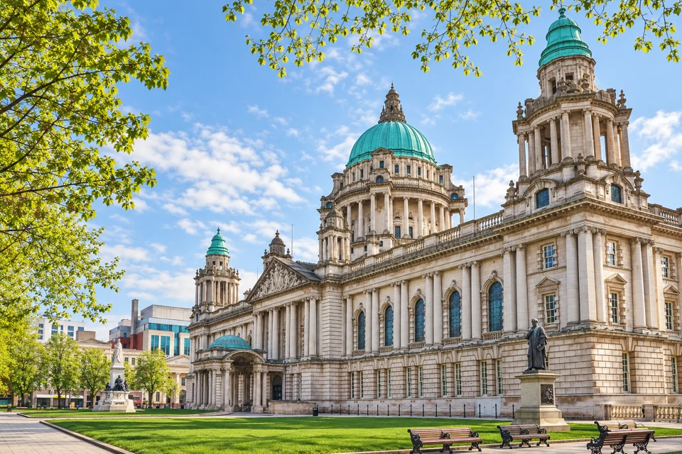 Belfast City Hall's pale stone frontage, green-copper domes, garden lawns and benches.