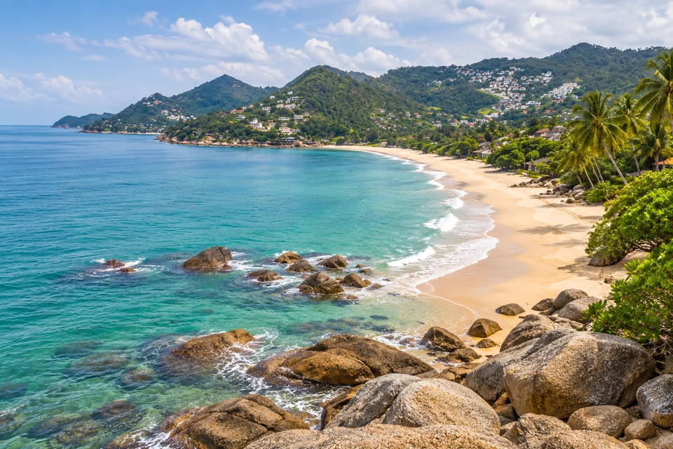 Lamai Beach on Koh Samui, with granite shore rocks, palms and a broad curved sand beach.