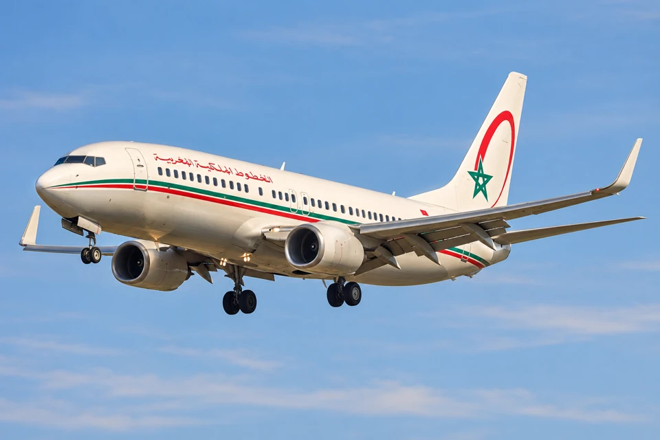 A Royal Air Maroc Boeing 737-800 with red and green fuselage stripes and landing gear down.
