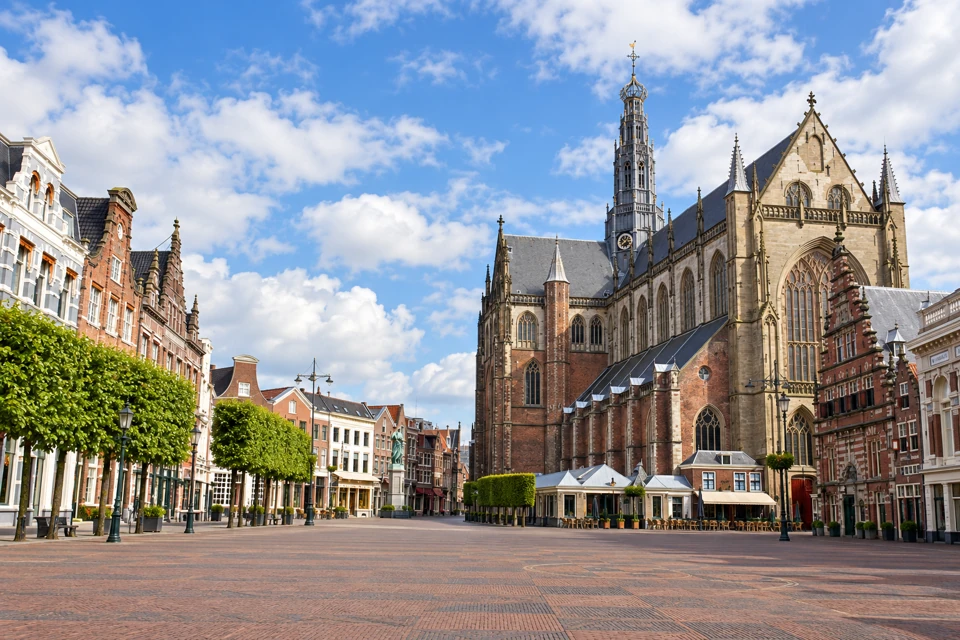 Haarlem's broad Grote Markt with St Bavo's Gothic transept and crossing tower beside gabled buildings.