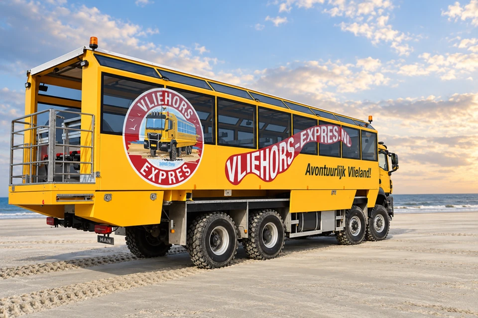 A yellow four-axle Vliehors Expres beach vehicle with an open-sided passenger body on Vlieland's broad sand plain.