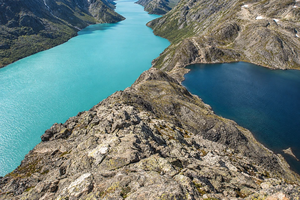 Besseggen's rocky ridge between milky turquoise Gjende on the left and dark-blue Bessvatnet on the right.