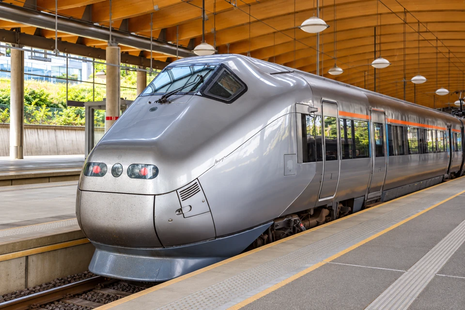 A silver Flytoget type 71 train beside an empty platform at Oslo Airport station.