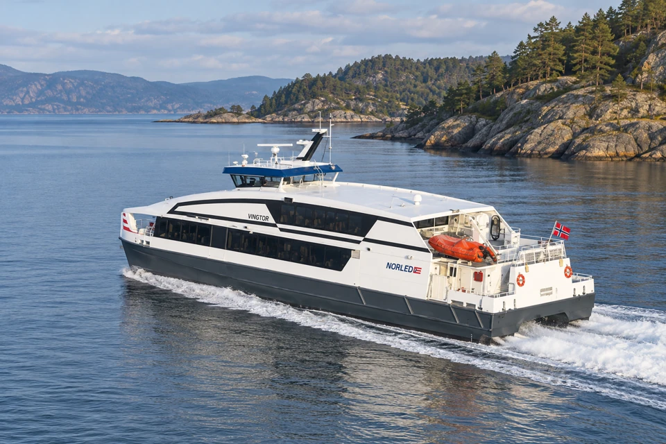 Norled's Vingtor passenger catamaran with enclosed windowed cabins and an orange rescue boat.
