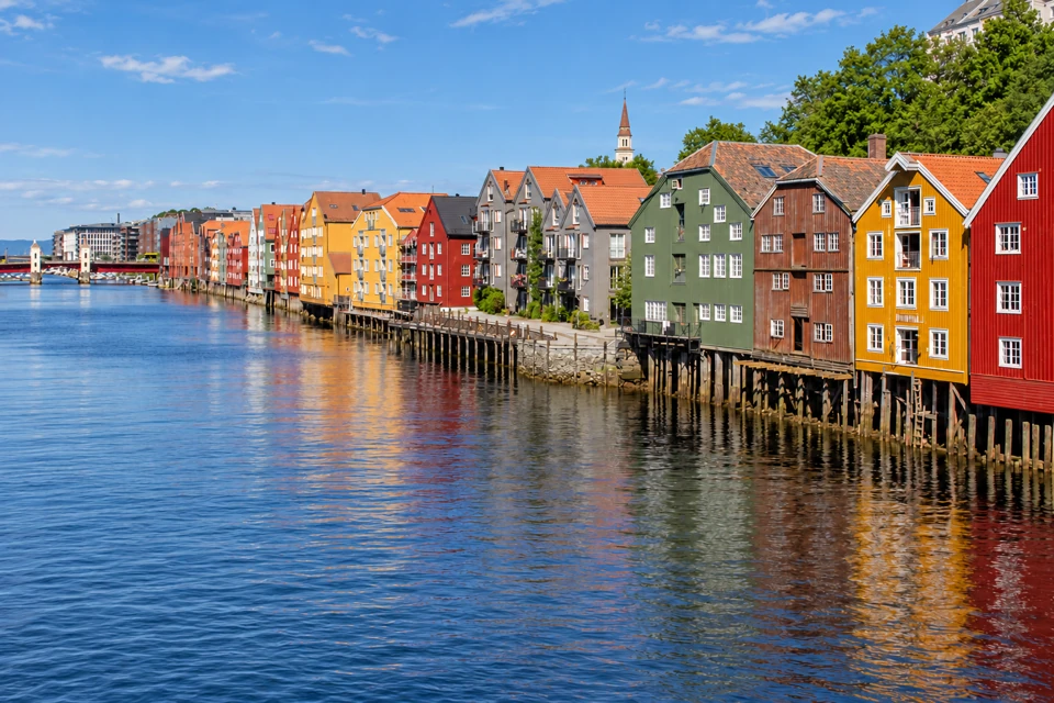 Trondheim's colorful gabled timber warehouses on wooden piles along the Nidelva River.