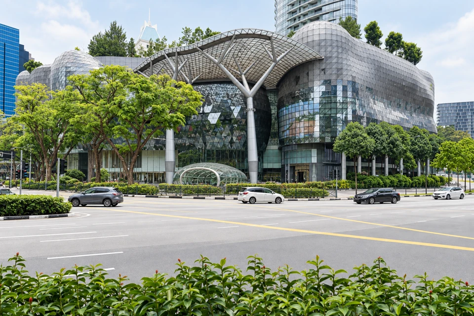 ION Orchard's curved glass facade and branching canopy beside Orchard Road.