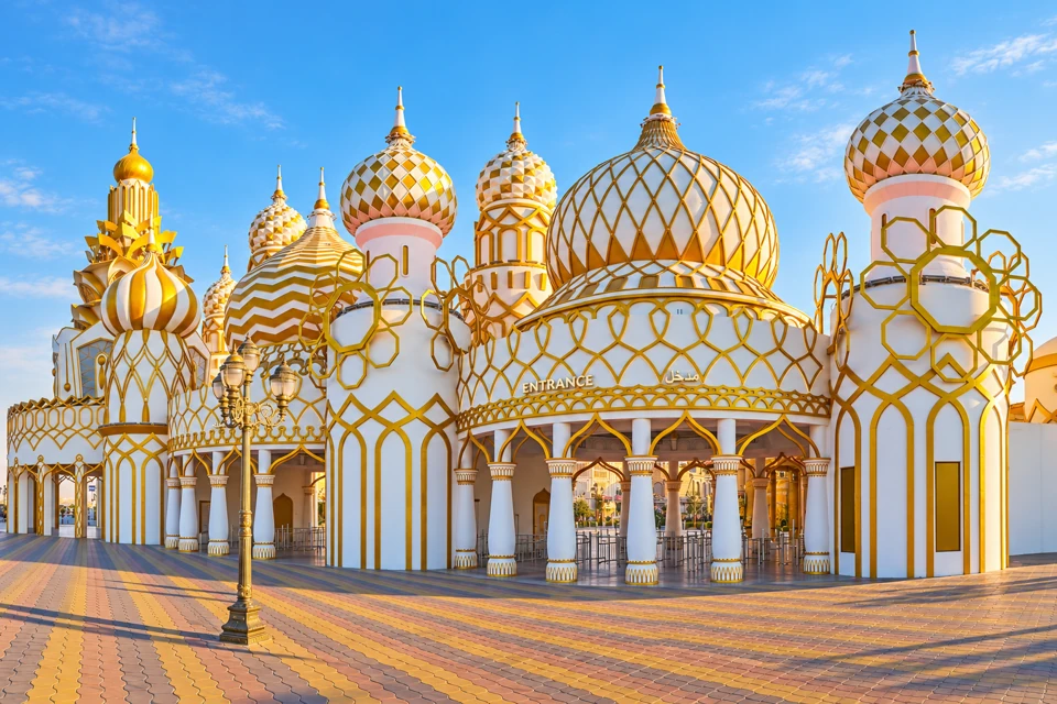 Global Village's white-and-gold onion-domed entrance and patterned plaza in Dubai.