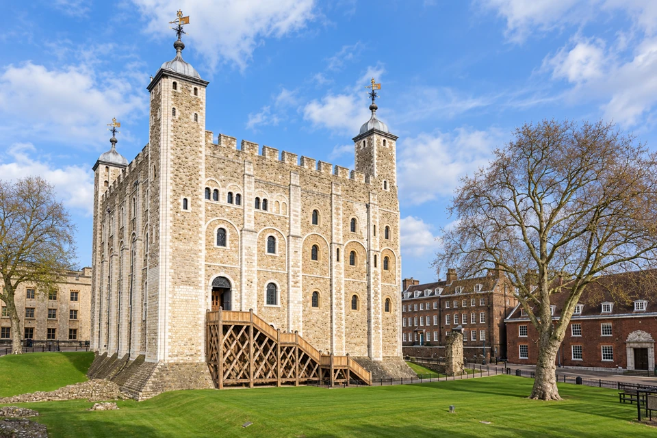 The White Tower at the Tower of London, with pale stone walls, lead-capped turrets, an oak entrance staircase and lawns.