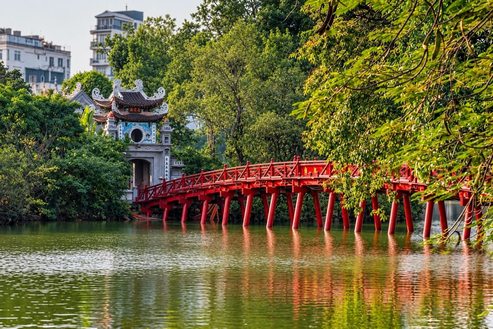 Red The Huc Bridge crossing Hoan Kiem Lake toward the Ngoc Son Temple entrance in Hanoi